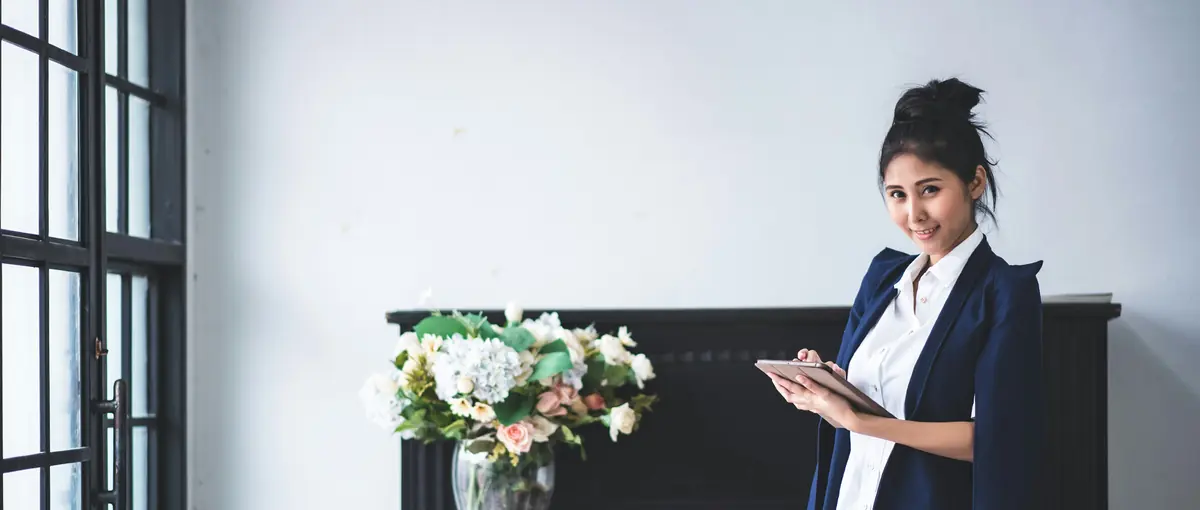A businesswoman holding a tablet in a bright office