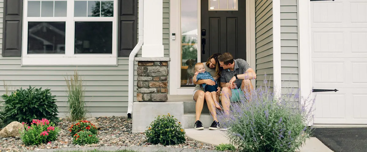 A family sitting together on the front porch of their home